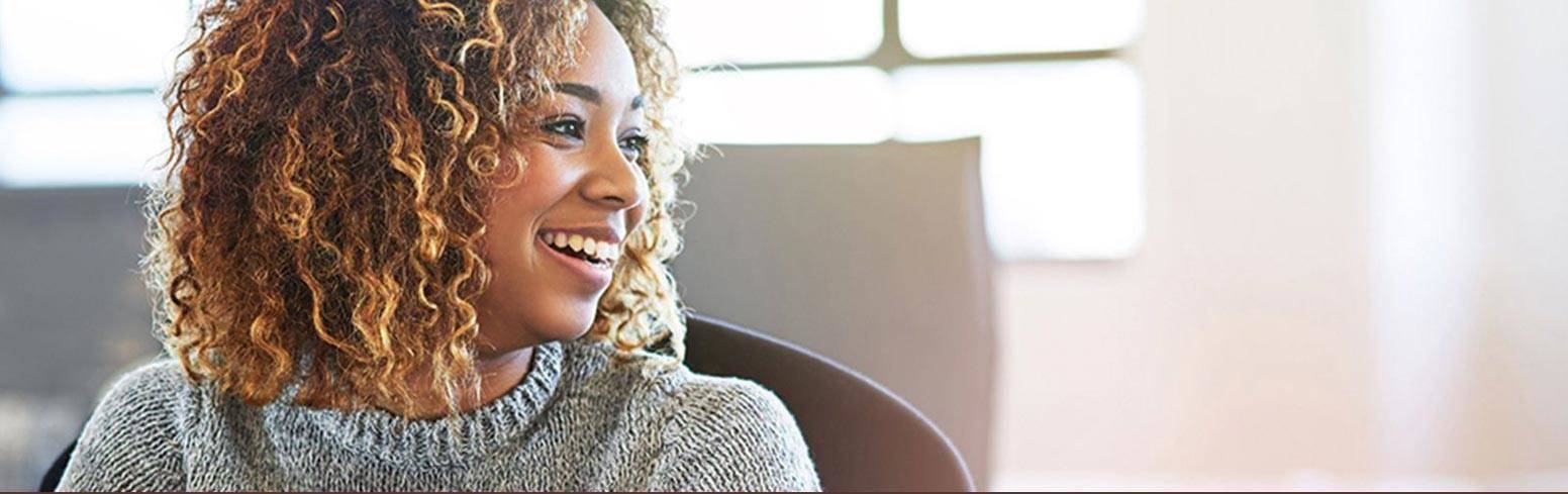 woman smiling in grey jumper