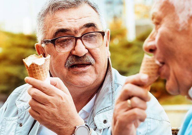 elderly man eating ice cream cone