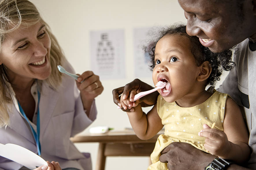 Dad brushing toddlers teeth