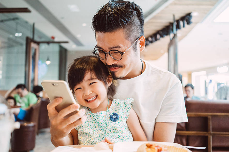 Father and daughter looking at phone