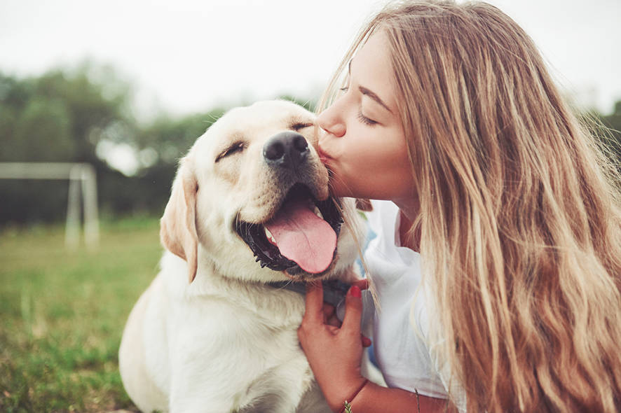 Girl kissing her dog