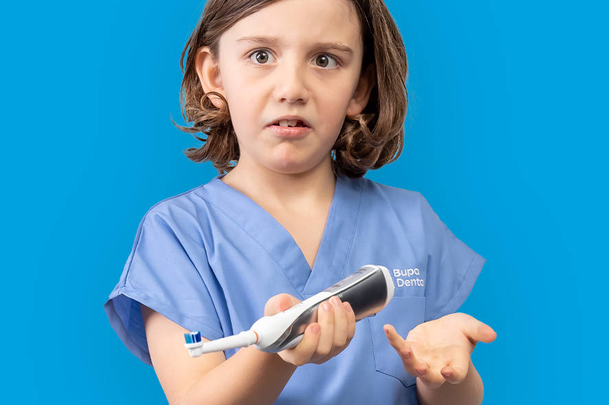 Child holding an electric toothbrush