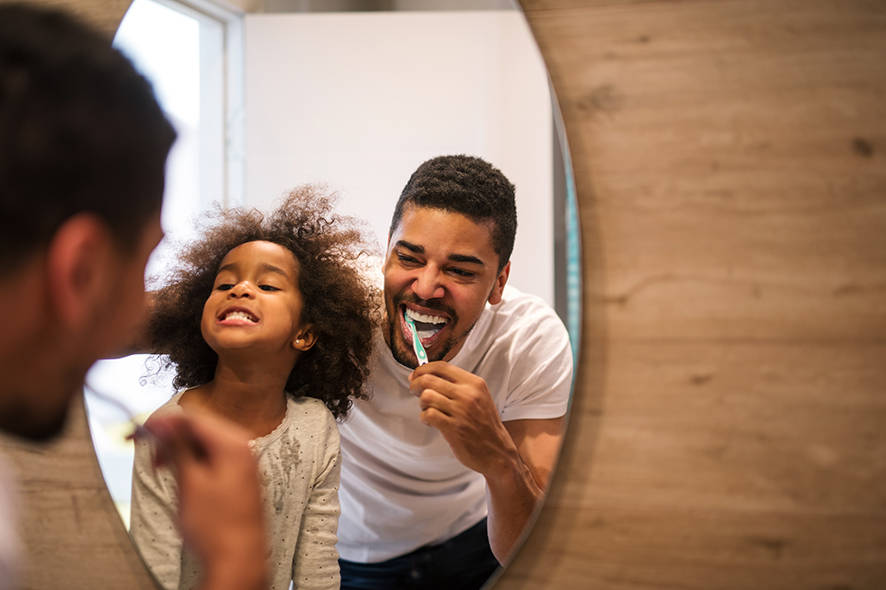 Dad and daughter brushing teeth