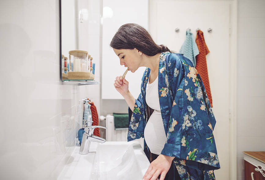 Pregnant lady brushing her teeth